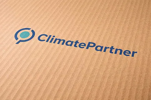 „ClimatePartner“-Logo auf Wellpappe gedruckt (Nahaufnahme).