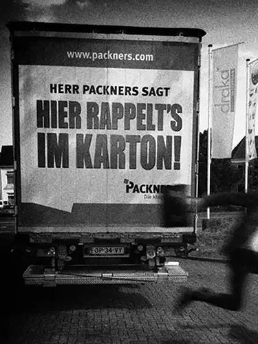Lkw-Heck mit Aufschrift: Herr Packners sagt: Hier rappelt’s im Karton!