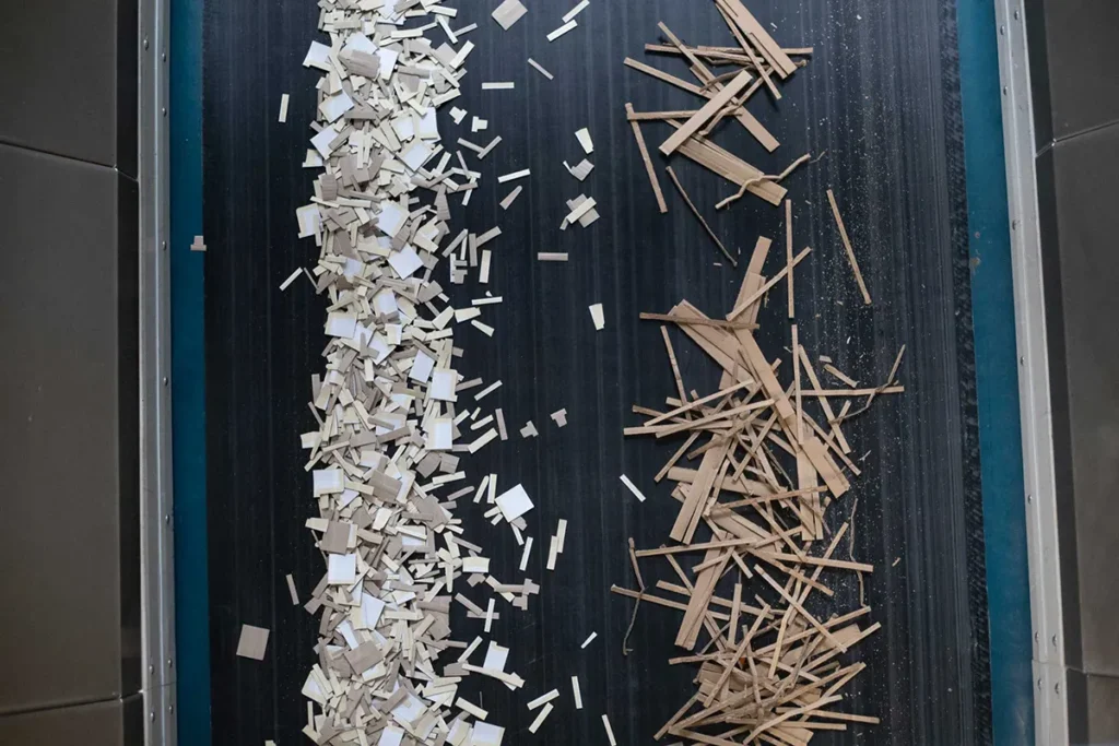 Pappreste und Kartonabschnitte auf einem Förderband zur Weiterverarbeitung im Recycling