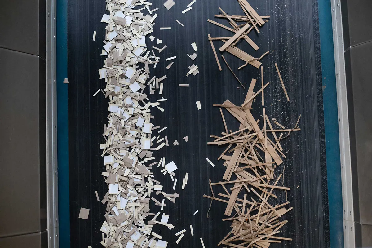 Pappreste und Kartonabschnitte auf einem Förderband zur Weiterverarbeitung im Recycling